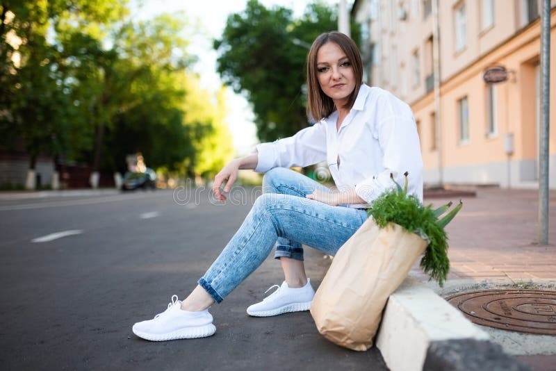 Schönes Mädchen mit Papiertüte mit Lebensmitteln. lizenzfreie stockfotografie