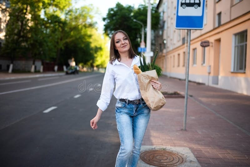Schönes Mädchen mit Papiertüte mit Lebensmitteln. lizenzfreies stockbild