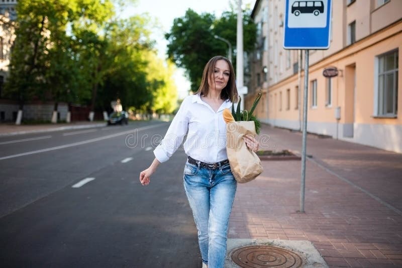 Schönes Mädchen mit Papiertüte mit Lebensmitteln. stockfoto