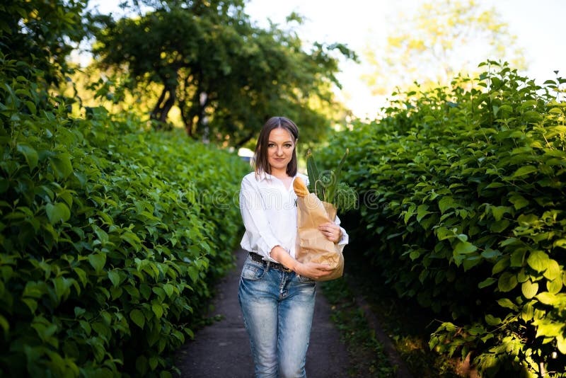 Schönes Mädchen mit Papiertüte mit Lebensmitteln. stockbild