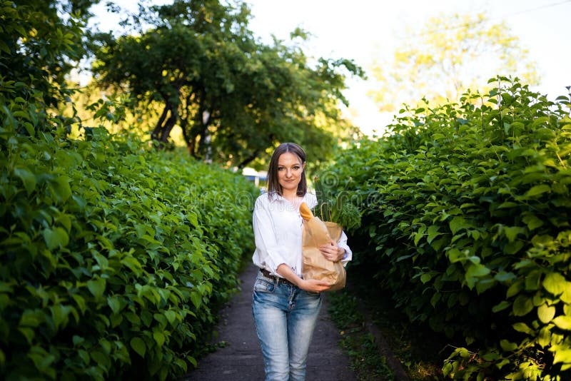 Schönes Mädchen mit Papiertüte mit Lebensmitteln. stockbild