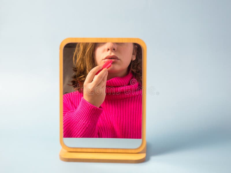 Schönes Mädchen schaut in den Spiegel lizenzfreies stockfoto