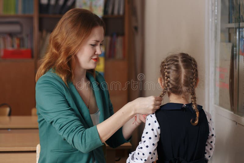 Schönes Mädchen und ihre junge Mutter, die zusammen ein Buch liest oder zu Hause studiert stockfotografie Schönes Mädchen und ihre junge Mutter, die zusammen ein Buch liest oder zu Hause studiert stockfotografie