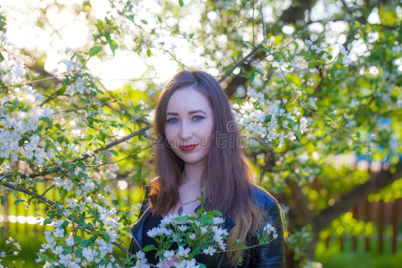 Schönes Mädchen unter dem florierenden Garten, blühen lizenzfreie stockfotos