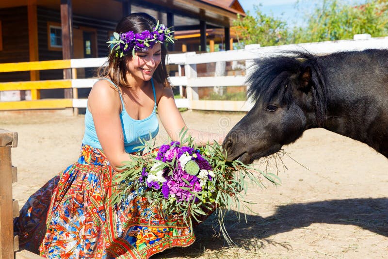 Schönes Mädchen, welches das Strohpony auf dem Bauernhof einzieht lizenzfreie stockfotos Schönes Mädchen, welches das Strohpony auf dem Bauernhof einzieht lizenzfreie stockfotos