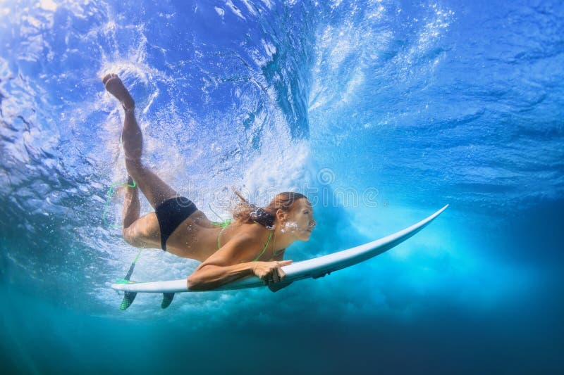 Schönes Surfermädchentauchen unter Wasser mit Brandungsbrett lizenzfreie stockbilder Schönes Surfermädchentauchen unter Wasser mit Brandungsbrett lizenzfreie stockbilder
