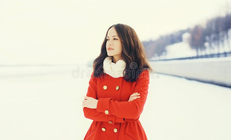 Schönheit, die einen roten Mantel und einen Schal über Schnee im Winter trägt stockbilder Schönheit, die einen roten Mantel und einen Schal über Schnee im Winter trägt stockbilder