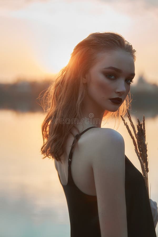 Schönheit ist im Wasser in einem Weiher bei Sonnenuntergang. sexy Frau im See lizenzfreie stockfotos