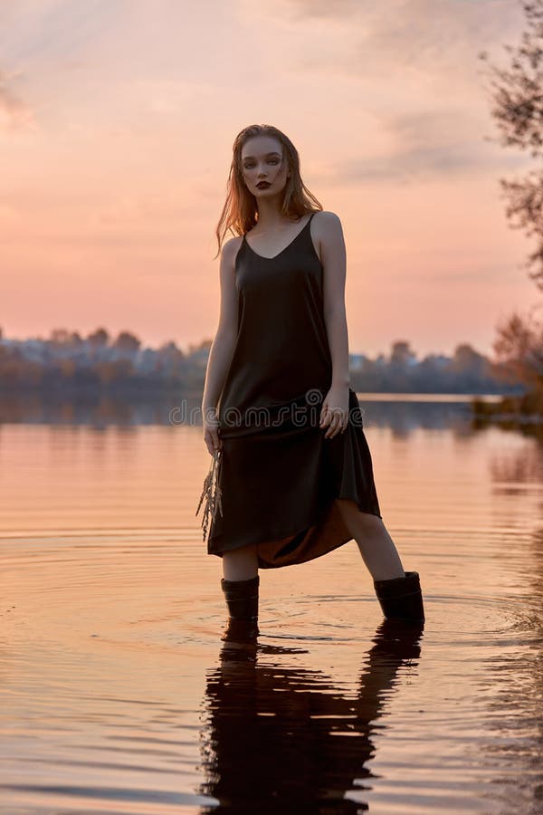 Schönheit ist im Wasser in einem Weiher bei Sonnenuntergang. sexy Frau im See lizenzfreies stockfoto