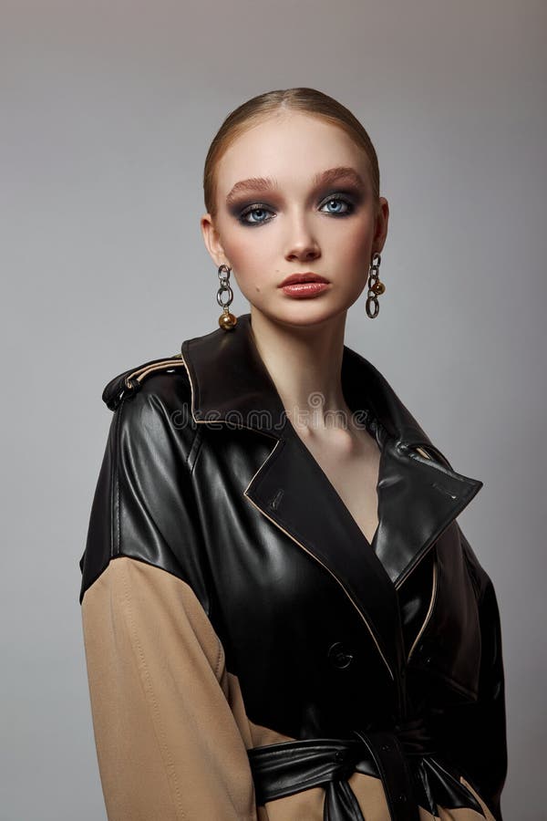 Schönheit Mode junge Frau in Trench Mantel professionelle Gesicht Make-up Mädchen. Frauenporträt auf weißem Hintergrund. Federklei lizenzfreies stockfoto
