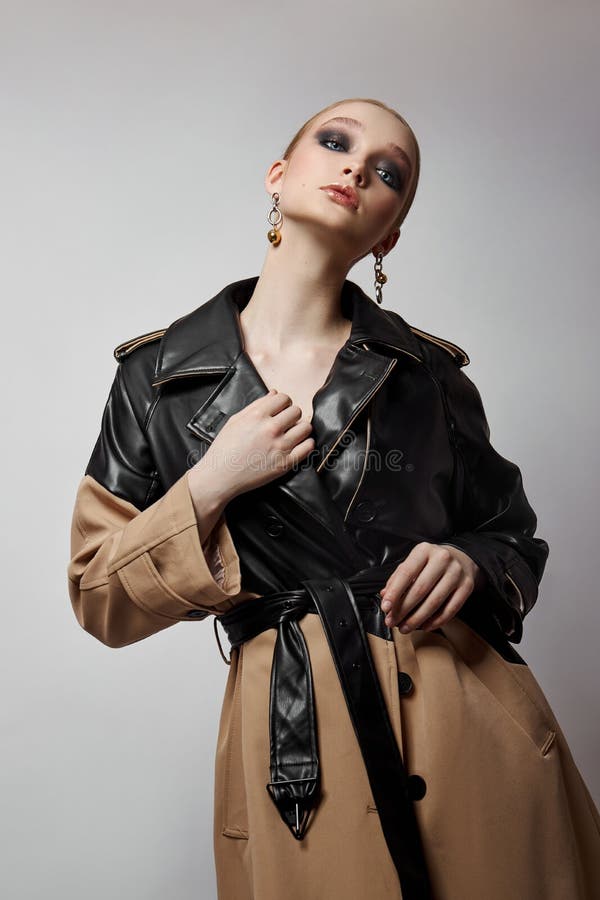 Schönheit Mode junge Frau in Trench Mantel professionelle Gesicht Make-up Mädchen. Frauenporträt auf weißem Hintergrund. Federklei lizenzfreie stockfotografie