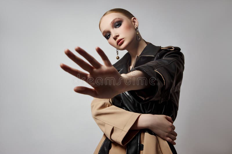 Schönheit Mode junge Frau in Trench Mantel professionelle Gesicht Make-up Mädchen. Frauenporträt auf weißem Hintergrund. Federklei stockbild