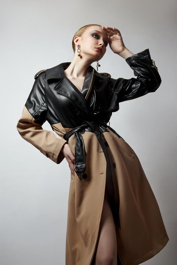 Schönheit Mode junge Frau in Trench Mantel professionelle Gesicht Make-up Mädchen. Frauenporträt auf weißem Hintergrund. Federklei stockfoto
