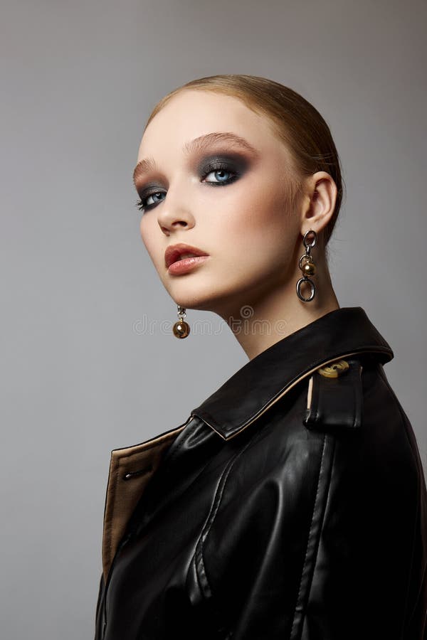 Schönheit Mode junge Frau in Trench Mantel professionelle Gesicht Make-up Mädchen. Frauenporträt auf weißem Hintergrund. Federklei lizenzfreie stockbilder