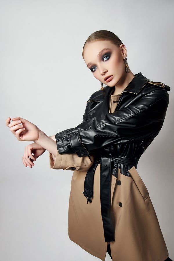 Schönheit Mode junge Frau in Trench Mantel professionelle Gesicht Make-up Mädchen. Frauenporträt auf weißem Hintergrund. Federklei lizenzfreie stockfotos