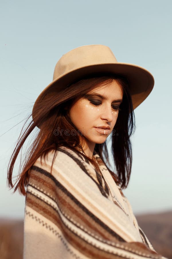 Schönheitshippie-Porträt, mit romantischem Blick-, Tragenhut und Poncho bei Sonnenuntergang in den Bergen, boho Reisekonzept lizenzfreies stockbild Schönheitshippie-Porträt, mit romantischem Blick-, Tragenhut und Poncho bei Sonnenuntergang in den Bergen, boho Reisekonzept lizenzfreies stockbild