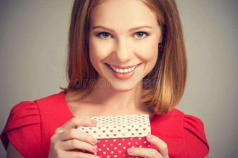 Schönheitsmädchen im roten Kleid mit Geschenkbox zum Geburtstag oder zum Valentinstag lizenzfreies stockfoto Schönheitsmädchen im roten Kleid mit Geschenkbox zum Geburtstag oder zum Valentinstag lizenzfreies stockfoto
