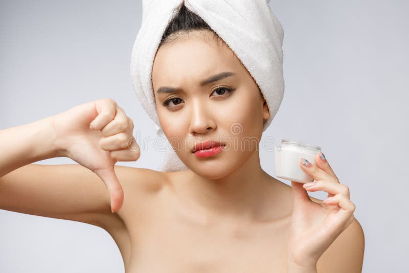 Schönheitsporträt der halb nackten asiatischen Frau, die auf Kamera schaut und Gesichtscreme auf ihrer Palme lokalisiert über Wei stockfotos Schönheitsporträt der halb nackten asiatischen Frau, die auf Kamera schaut und Gesichtscreme auf ihrer Palme lokalisiert über Wei stockfotos