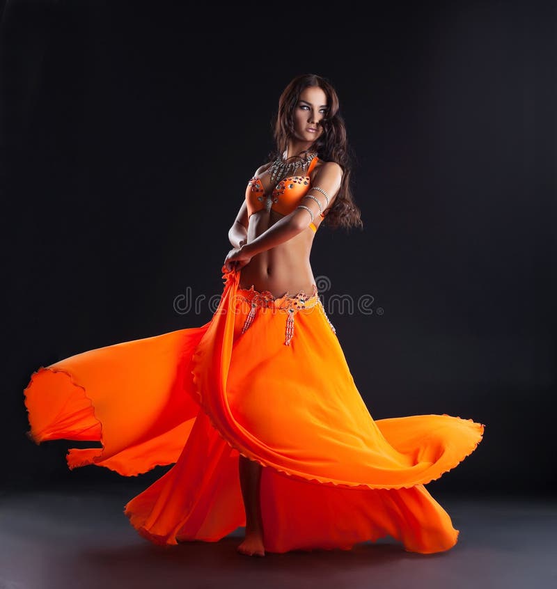 Schönheitstänzer, der im traditionellen orange Kostüm aufwirft lizenzfreies stockfoto Schönheitstänzer, der im traditionellen orange Kostüm aufwirft lizenzfreies stockfoto