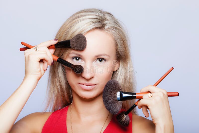 Schönheitsverfahren, Frau hält Make-upbürsten nahe Gesicht. stockbild Schönheitsverfahren, Frau hält Make-upbürsten nahe Gesicht. stockbild
