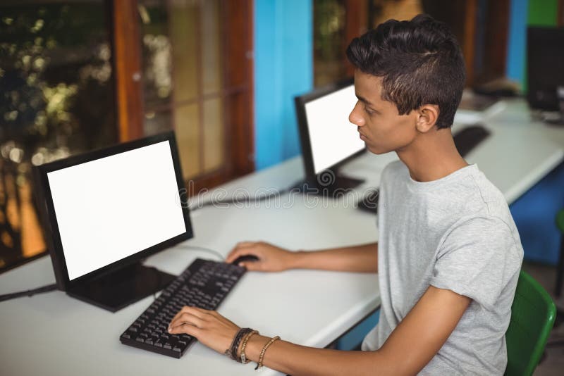 Schüler, der im Computerklassenzimmer studiert lizenzfreie stockfotos Schüler, der im Computerklassenzimmer studiert lizenzfreie stockfotos