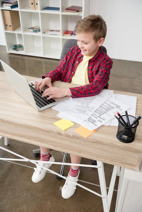 Schüler, der Vaterlaptop im Büro verwendet stockfoto Schüler, der Vaterlaptop im Büro verwendet stockfoto