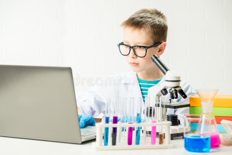 Schüler mit Laptop im Labor führt chemische Experimente mit Substanzen im Reagenzglas-Portrait durch lizenzfreie stockfotografie