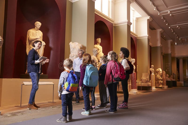 Schüler und Lehrer-On School Field-Reise zum Museum mit Führer stockfotografie Schüler und Lehrer-On School Field-Reise zum Museum mit Führer stockfotografie