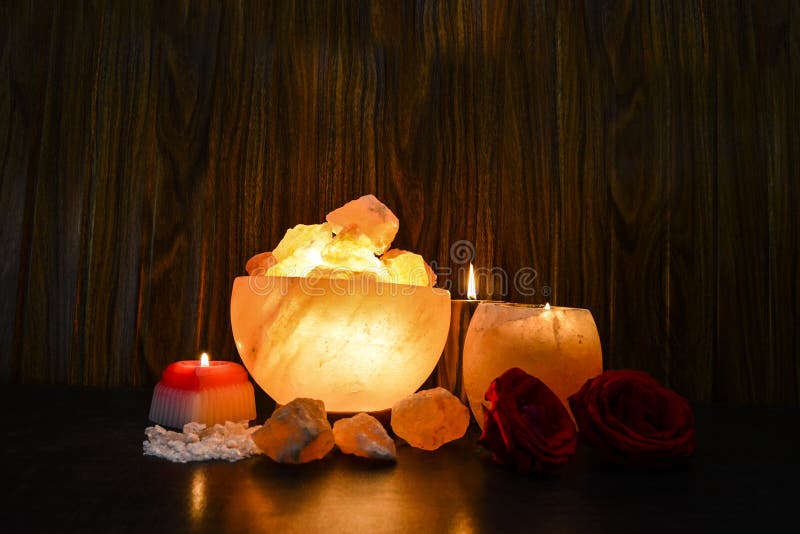 Bowl Chunks Lamps & Natural Salt Candle Handler with wooden & black background. Natural salt lamps are famous all over the world for their unique beautiful light. These salt lamps emit colorful apricot, yellow & orange light. These are carefully crafted from rock salt taken from mines in Salt Range Mountain located near Quaidabad, Khushab, Pakistan. Natural salt lamps are used to decorate drawing rooms, offices & bedrooms. It ionizes and purifies the air which can be very healthful for patients with asthma, joint pains & allergies. Today, the health benefits of ionizers are well recognized; whilst most ionizers in the market are manmade, the crystal salt lamps are Mother Nature`s beautiful alternative to cleanse & deodorize air. Bowl Chunks Lamps & Natural Salt Candle Handler with wooden & black background. Natural salt lamps are famous all over the world for their unique beautiful light. These salt lamps emit colorful apricot, yellow & orange light. These are carefully crafted from rock salt taken from mines in Salt Range Mountain located near Quaidabad, Khushab, Pakistan. Natural salt lamps are used to decorate drawing rooms, offices & bedrooms. It ionizes and purifies the air which can be very healthful for patients with asthma, joint pains & allergies. Today, the health benefits of ionizers are well recognized; whilst most ionizers in the market are manmade, the crystal salt lamps are Mother Nature`s beautiful alternative to cleanse & deodorize air.