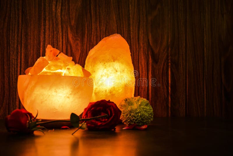 Glowing Bowl Chunks & Natural Salt Lamps with wooden & black background. Natural salt lamps are famous all over the world for their unique beautiful light. These salt lamps emit colorful apricot, yellow & orange light. These are carefully crafted from rock salt taken from mines in Salt Range Mountain located near Quaidabad, Khushab, Pakistan. Natural salt lamps are used to decorate drawing rooms, offices & bedrooms. It ionizes and purifies the air which can be very healthful for patients with asthma, joint pains & allergies. Today, the health benefits of ionizers are well recognized; whilst most ionizers in the market are manmade, the crystal salt lamps are Mother Nature`s beautiful alternative to cleanse & deodorize air. Glowing Bowl Chunks & Natural Salt Lamps with wooden & black background. Natural salt lamps are famous all over the world for their unique beautiful light. These salt lamps emit colorful apricot, yellow & orange light. These are carefully crafted from rock salt taken from mines in Salt Range Mountain located near Quaidabad, Khushab, Pakistan. Natural salt lamps are used to decorate drawing rooms, offices & bedrooms. It ionizes and purifies the air which can be very healthful for patients with asthma, joint pains & allergies. Today, the health benefits of ionizers are well recognized; whilst most ionizers in the market are manmade, the crystal salt lamps are Mother Nature`s beautiful alternative to cleanse & deodorize air.