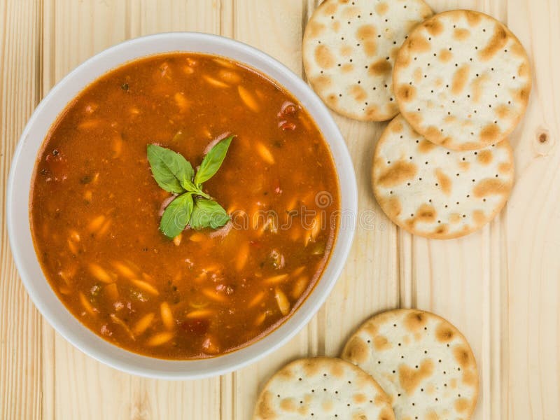 Schüssel traditionelle italienische Art-Minestra-Suppe mit Wasser-Keks-Crackern lizenzfreie stockbilder Schüssel traditionelle italienische Art-Minestra-Suppe mit Wasser-Keks-Crackern lizenzfreie stockbilder