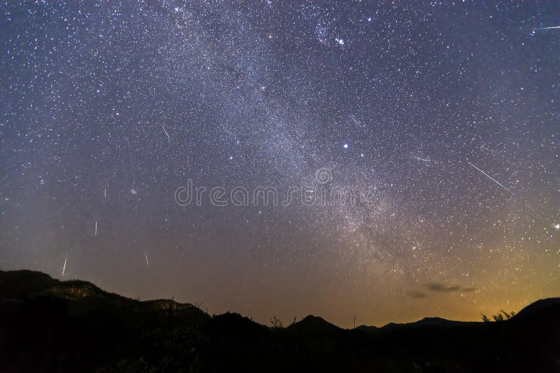 Sciame meteorico di Geminid e la Via Lattea sopra una montagna Meteora di Geminid nel cielo notturno immagine stock Sciame meteorico di Geminid e la Via Lattea sopra una montagna Meteora di Geminid nel cielo notturno immagine stock