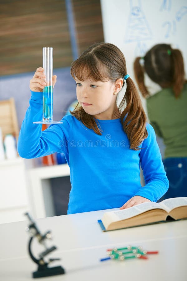 Elemental edad mira a tubo en ciencia la clase sobre el primario.