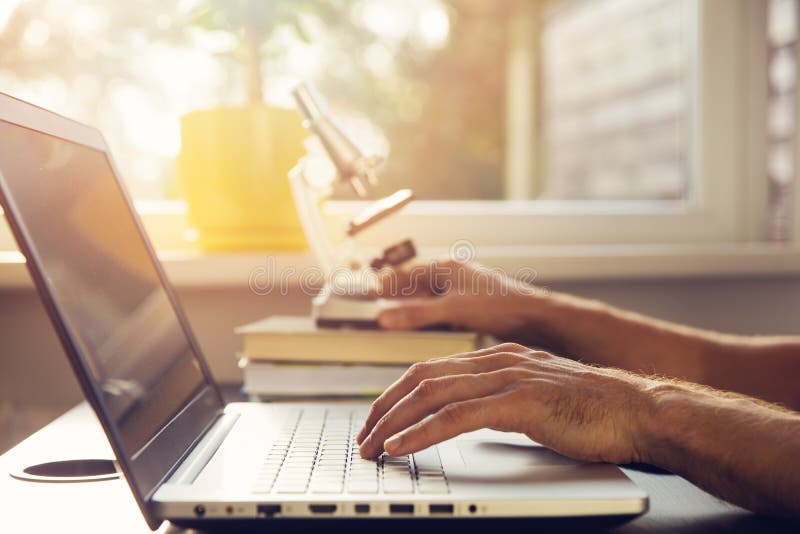Science education - new scientist working with laptop and micros stock photo