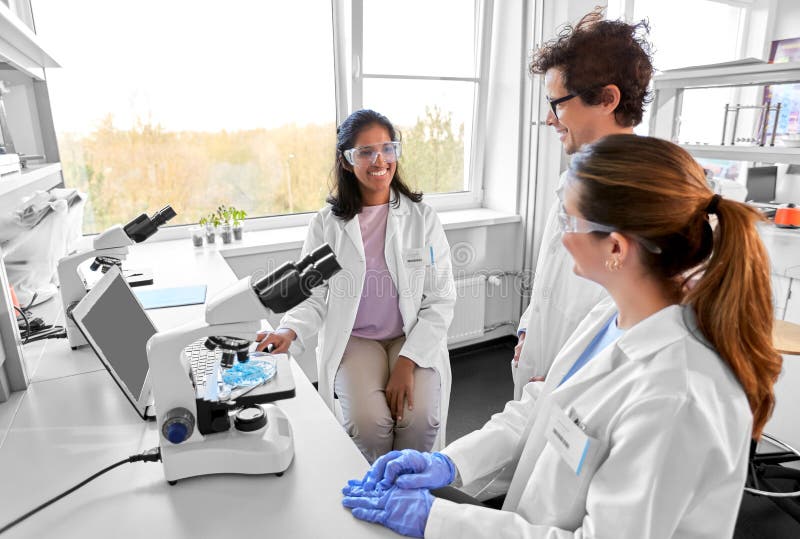 Scientists with microscopes working in laboratory stock images
