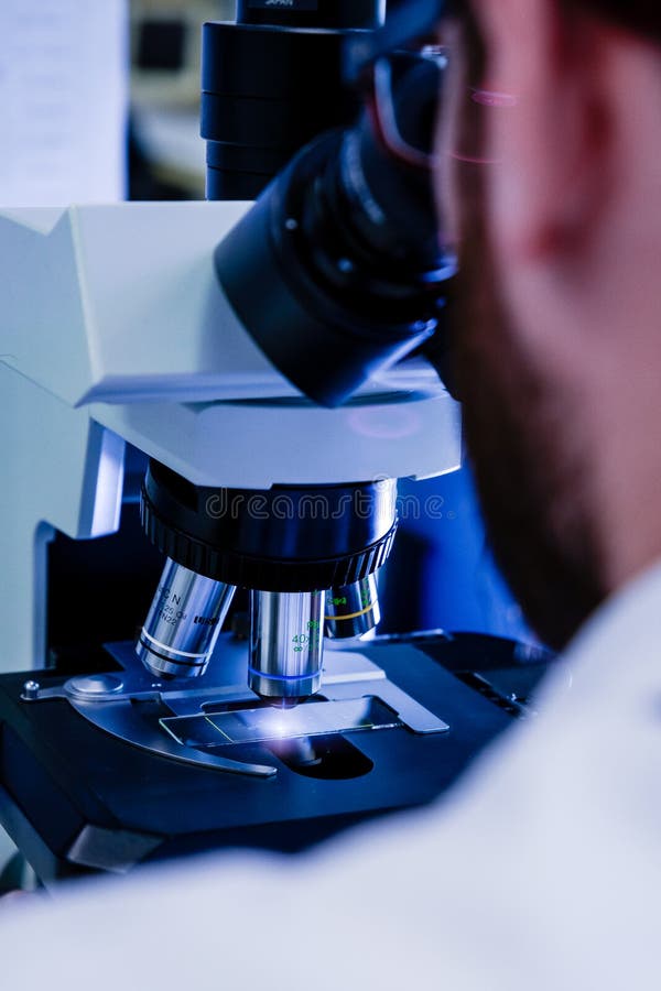 Scientific Handling a Light Microscope Examines a Laboratory Sample for