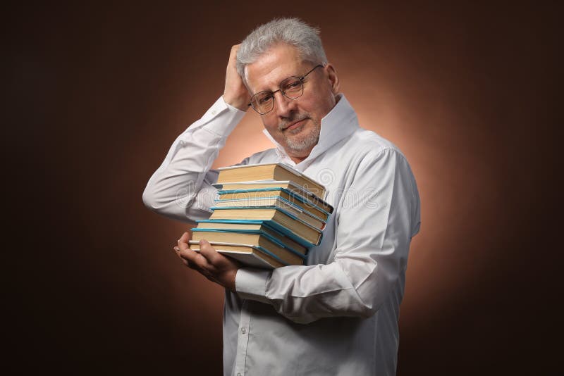 Scientific thinker, philosophy, elderly gray-haired man in a white shirt with a books, with studio light stock images Scientific thinker, philosophy, elderly gray-haired man in a white shirt with a books, with studio light stock images