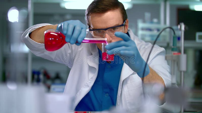 Scientifique dans le laboratoire faisant la recherche médicale Le technicien de laboratoire versent le liquide