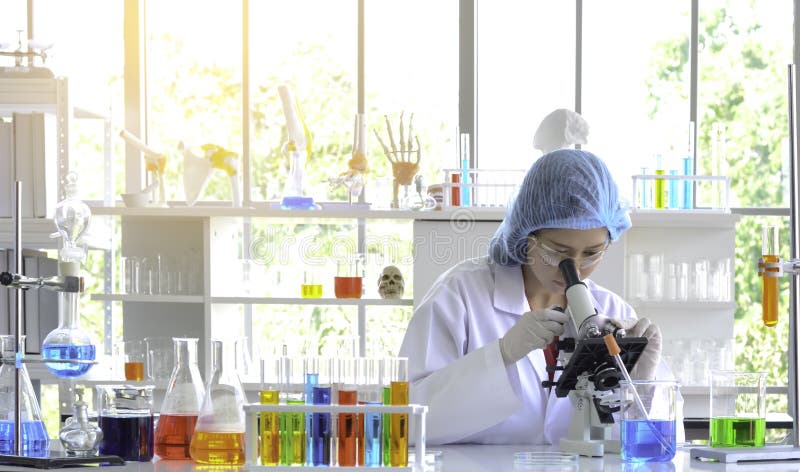 Scientifique de femme faisant l'expérience avec le microscope image stock Scientifique de femme faisant l'expérience avec le microscope image stock