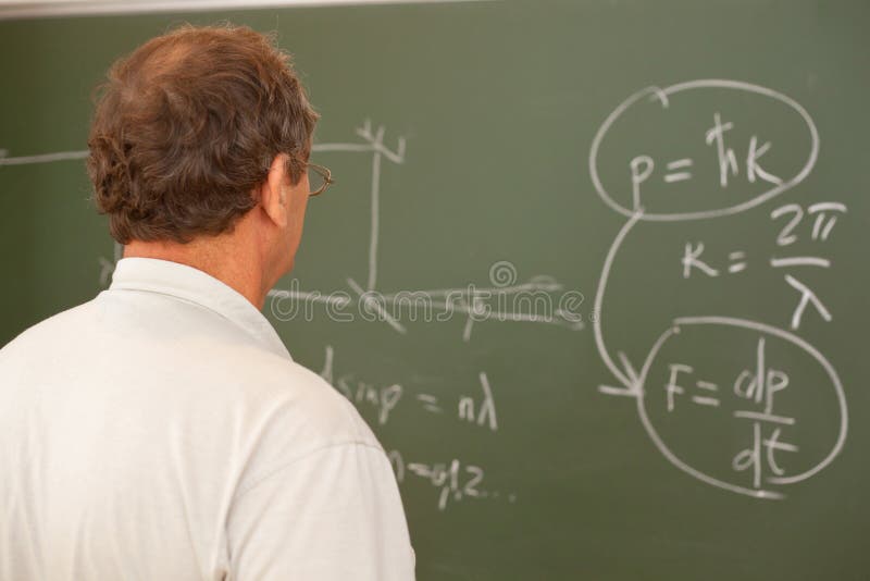 Scientist looking at formula on blackboard, back. Scientist looking at formula on blackboard, back