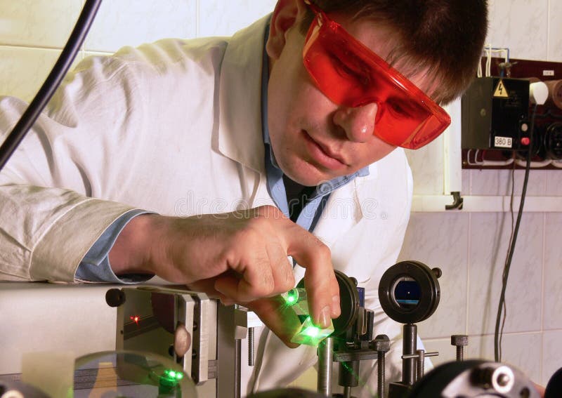 Joven científico tiene experiencias verde haz de rayo en laboratorio.