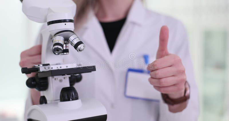 Scientist biologist or laboratory technician p holding microscope and thumb up stock video footage