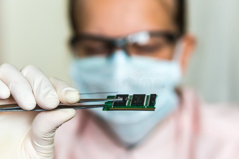 Scientist holding and examining damaged electrical component stock images Scientist holding and examining damaged electrical component stock images