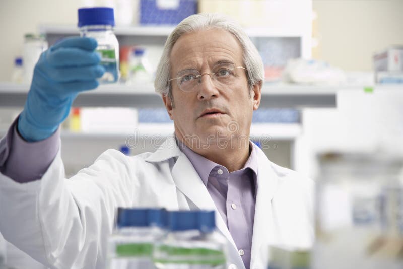 Scientist Looking At Specimen Bottle In Laboratory Stock Photo Image