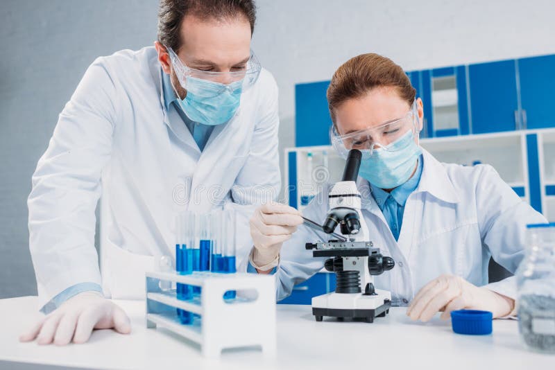 Científicos en blanco abrigos, médico guantes a gafas de proteccion creación científico investigación común en laboratorio.