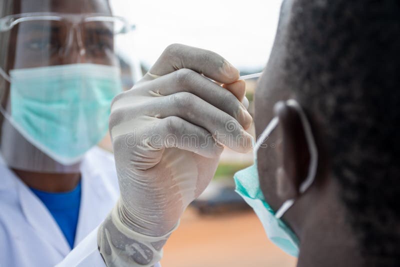 Young black lab scientist taking nasal sample from a patient. Young black lab scientist taking nasal sample from a patient