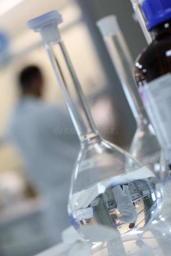 Closeup of scientist reflected in flask shaped test tube. Closeup of scientist reflected in flask shaped test tube.