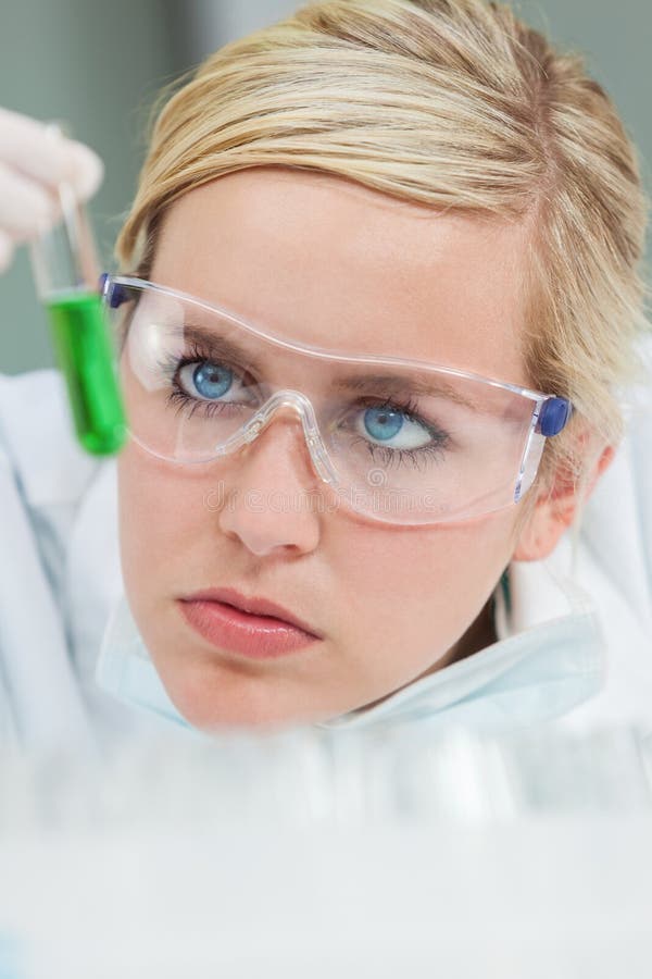 Scienziato femminile & provetta verde in laboratorio immagini stock Scienziato femminile & provetta verde in laboratorio immagini stock