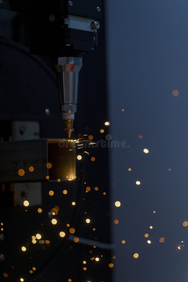 Scintille durante il taglio laser metallico di metallo su una macchina per il taglio automatico di metallo fotografia stock