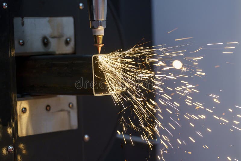 Scintille durante il taglio laser metallico di metallo su una macchina per il taglio automatico di metallo immagine stock